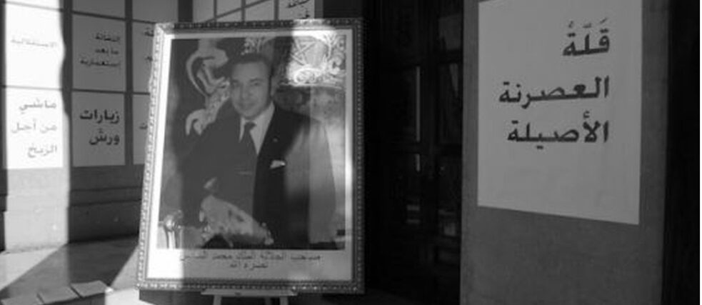 A black and white photo of a man surrounded by Arabic writing
