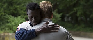 Francis (Welket Bungué) e Reinhold (Albrecht Schuch) si abbracciano