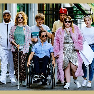 Verschiedene Menschen laufen über die Straße