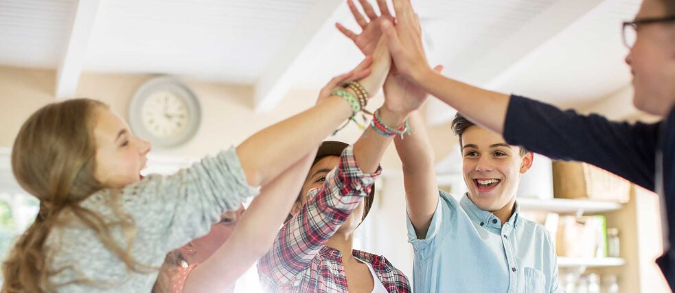 Courses for Teenagers: a group of teenagers high-fives each other