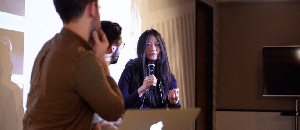 Clara Jo talking to a crowd with microphone 