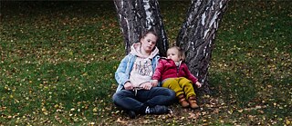 deux enfants assis au pied d'un arbre