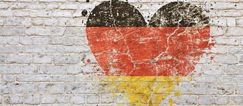 Německá vlajka nastříkaná ve tvaru srdce na cihlové zdi