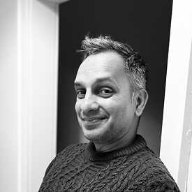 Black and white portrait of a man looking directly into the camera.