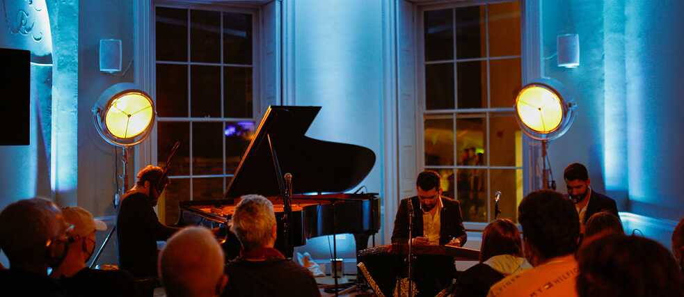 Lambert, playing piano, and Nava, playing string instruments, at 37 Merrion Square