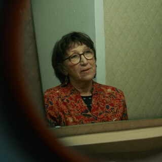 Woman with glasses looking in the mirror