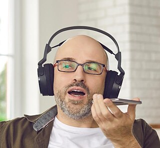Mann mit Kopfhörern spricht in ein Handy © © Colourbox Mann mit Kopfhörern spricht in ein Handy