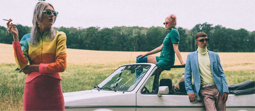 Die Band Blond steht mit einem Auto im Feld
