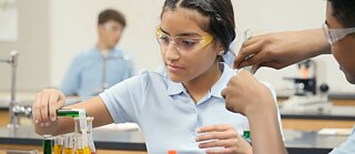 Eine Schülerin führt ein Chemieexperiment in einem Klassenzimmer durch © © Getty Images Banner JuniorUniversum