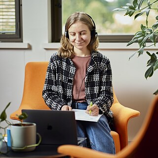 Women sitting in front of ipad focusing on her online lecture