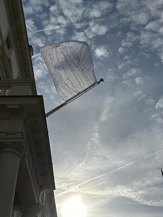 The flag hanging outside the Goethe-Institut London with cloudy sky 