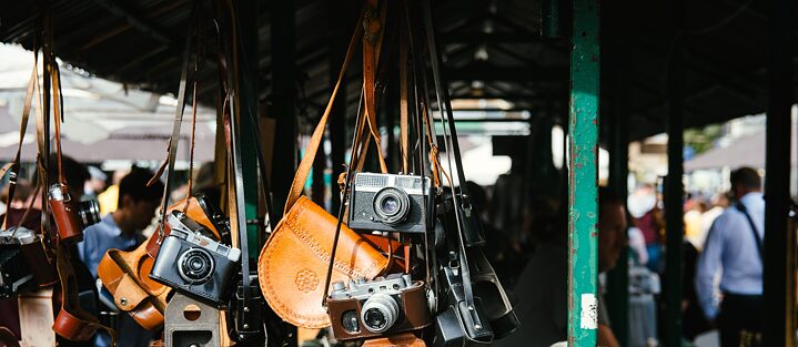 An einem Flohmarktstand hängen mehrere alter Kameras
