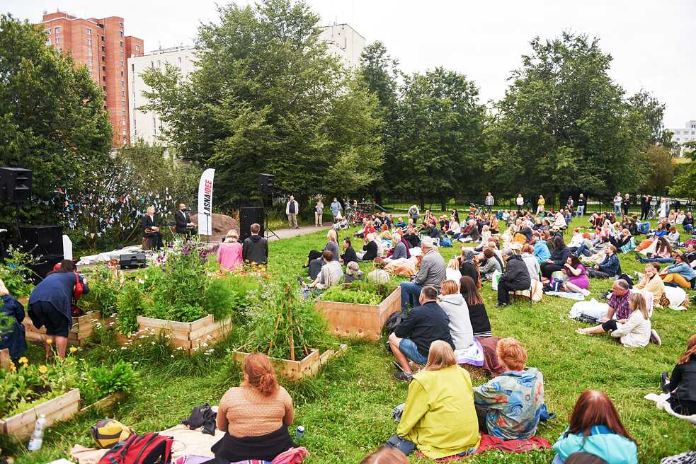 Menschen jeden Alters schauen im Stadtteil Lasnamäe auf der Straße einen Film an.