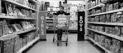Ein kleiner Junge mit einem Einkaufswagen im Spielzeugladen