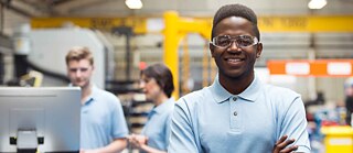 jovem veste roupas de trabalho olha para câmera e sorri