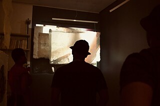 People in a dark room silhouetted against the light 