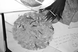 Decorated hand of lady touching a piece of art on a table