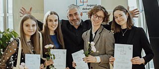 April 2022: Landesfinale des Wettbewerbs „Jugend debattiert in Mittel-, Ost- und Südosteuropa“. Im Bild der Schirmherr des Wettbewerbs 2022, Gundars Āboliņš, mit den Finalist*innen Emili Lele, Agneta Labalaika, Alberts Roze, Paula Lībeka.