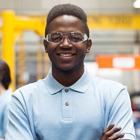 jovem veste roupas de trabalho olha para câmera e sorri