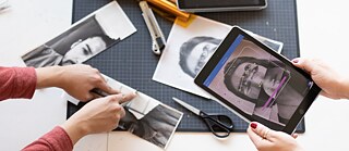 Portrait photographies on a table are being cut up and artistically altered