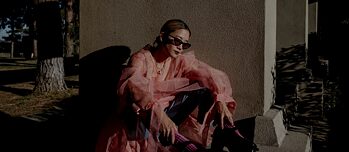 Ein Foto von Christine, die draußen mit einer Sonnenbrille sitzt
