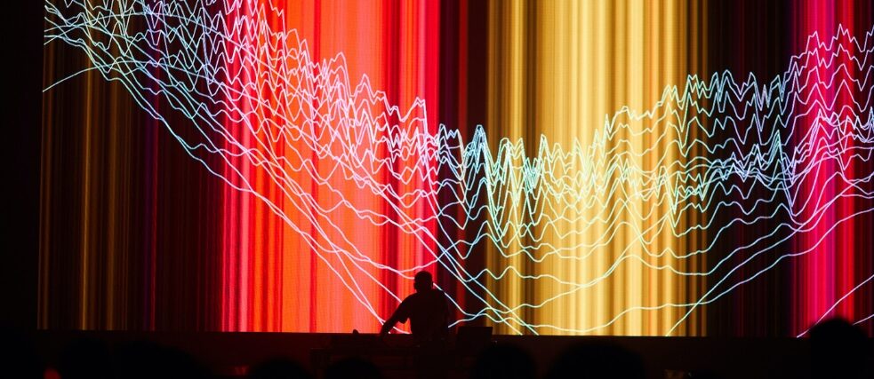 Carsten Nicolai playing live with visual show behind him 