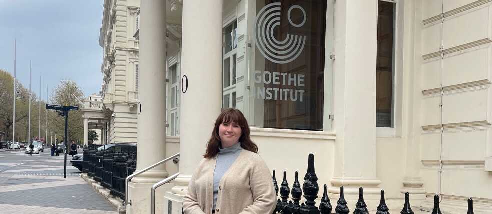 Sarah standing outside the Institut with cream jumper