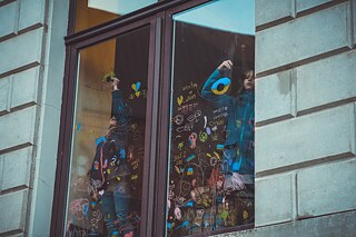 Oktober 2022, Fenster des Projekts Hearing Voices Café. Das Projekt wird sich mit den Konzepten der Demokratie, der Redefreiheit und der Meinungsäußerung im Kontext des lettischen Erwachens, des ukrainischen Krieges und der heutigen politischen Vielfalt befassen. Die Fotos wurden während des Malworkshops mit Collageelementen "Grüner Himmel und blaue Erde" aufgenommen, als die Kinder über Dinge und Ereignisse nachdachten, die sie schützen und für die sie sich einsetzen möchten. “Heraing Voices Café" fand im Rahmen des Festivals für zeitgenössische Kunst "Survival Kit 13" in Zusammenarbeit mit dem langjährigen Partner Latvian Centre for Contemporary Art (LCCA) statt.