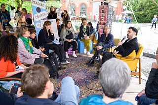 People sit in a circle and listen to a reading.