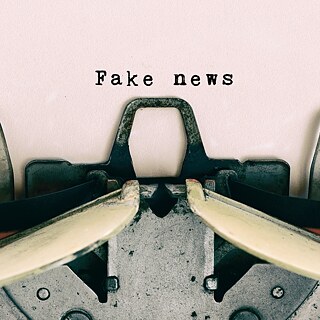Schreibmaschine, die ein Papier, worauf "Fake News" steht, ausdruckt