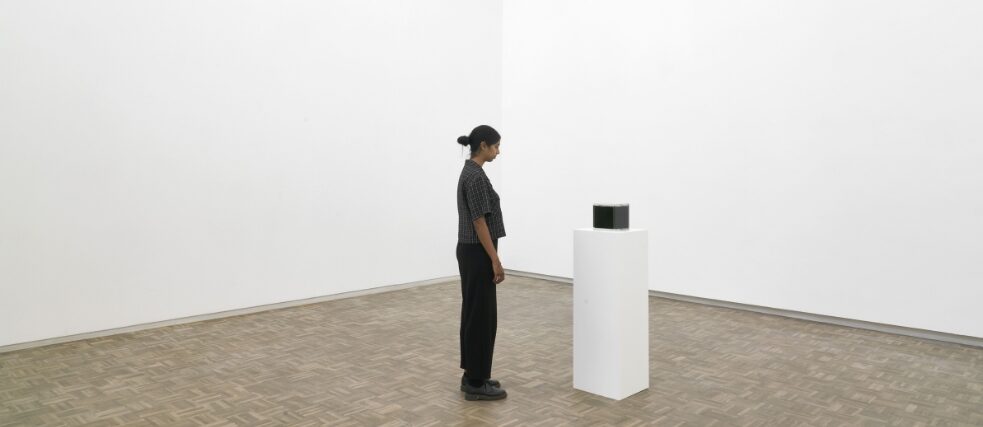 A woman standing in front of Nigerian crude oil as part of the Series of Personal Questions exhibition