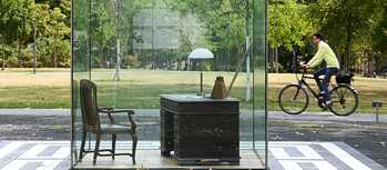 A desk with a lamp, metronome and book on it and an empty chair inside a glass box: this is a memorial on Frankfurt’s Goethe University campus to the philosopher Theodor W. Adorno.