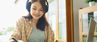 junge Studentin schaut in die Kamera und lächelt