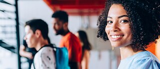 jovem estudante mulher olha para a câmera e sorri &copy;   Curso preparatório Studienkolleg B1