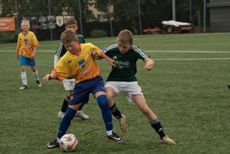 Zwei Kinder spielen Fußball.
