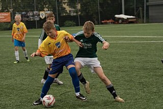 Zwei Kinder spielen Fußball.