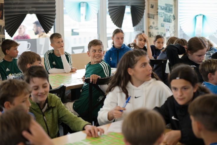 Schüler*innen sitzen beisammen.