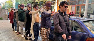 Menschen machen einen Spaziergang mit verbundenen Augen