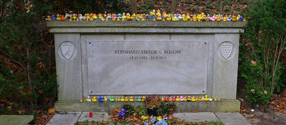 So legendary that all kinds of different versions of the rubber duck that is the bone of contention between the two gentlemen have found their way onto Loriot’s grave.