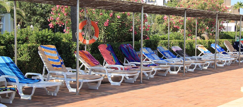 3,2,1 – meins! Nicht ganz – beim Handtuchauswerfen am Hotelpool werden die Deutschen doch glatt von den Brit*innen geschlagen. 