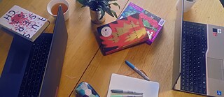 Books, laptops, pens, note book and a drink placed on the floor