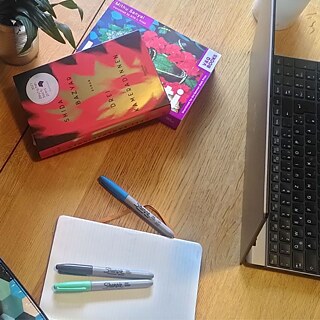 Books, laptops, pens, note book and a drink placed on the floor