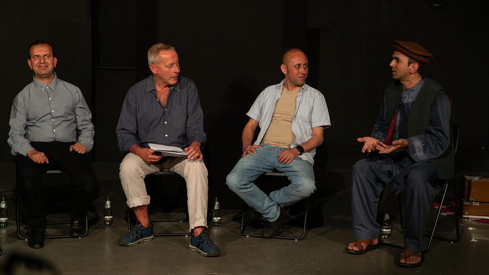 Shir Khan Ahmadzai, Wieland Jagodzinski, Homan Wesa und Abdul Haq Haqjoo sitzen nebeneinander. Abdul Haq Haqjoo spricht.