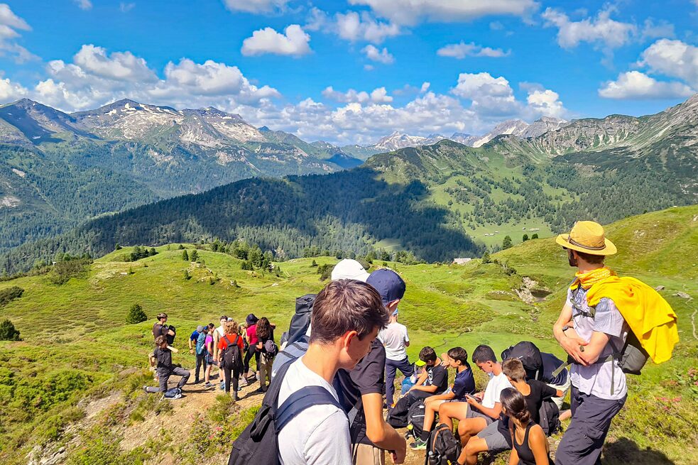 Jugendliche auf einem Wanderweg in den Bergen machen Rast.