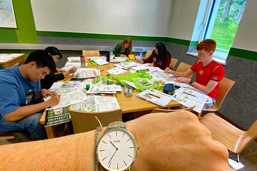 Jugendliche sitzen an einem Tisch und arbeiten konzentriert.