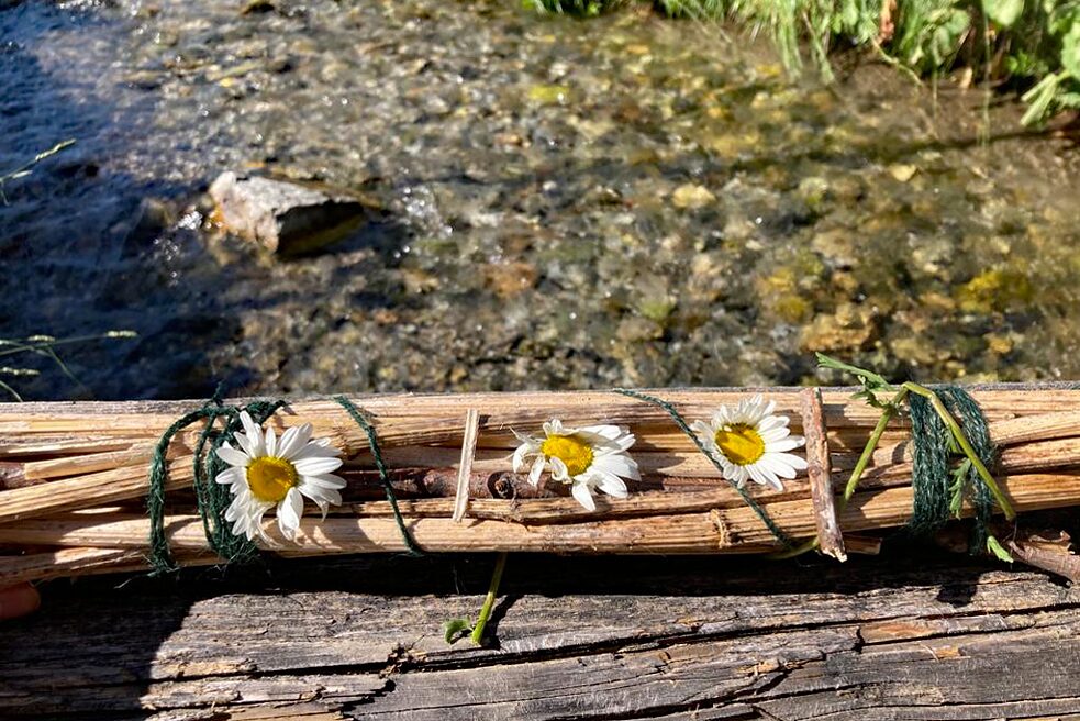 Ein kleines Floß, darauf drei Margerittenblüten