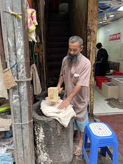 Man curshing ice before preparing Lassi 