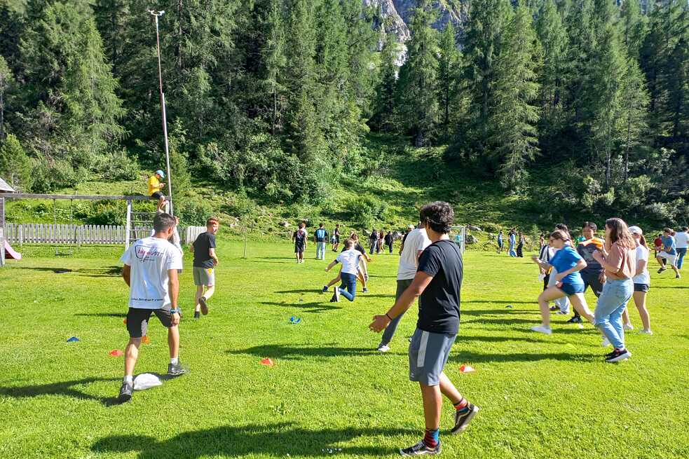 Jugendliche spielen Ball auf einer großen Wiese.