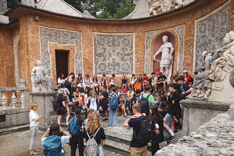 Jugendliche lauschen einer Führung im Theatrum der Wasserspiele Hellbrunn