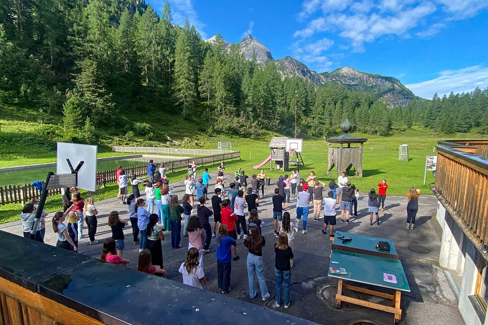 Jugendliche tanzen auf einem Hof.